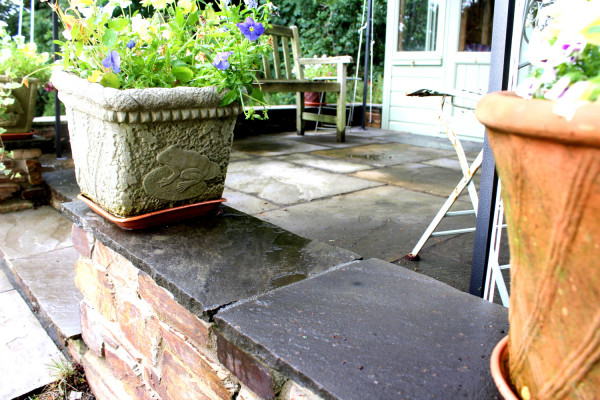 Black sandstone paving slabs used to cap a wall