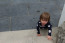 Child playing on a black limestone paving patio 